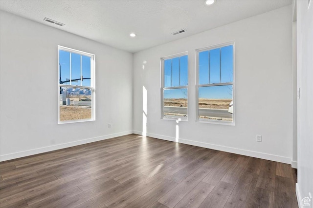 unfurnished room featuring dark wood-type flooring, recessed lighting, and baseboards