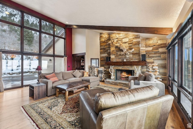 4552 S Zarahemla Dr E, Salt Lake City, UT 84124 - living area featuring a stone fireplace, beamed ceiling, and wood finished floors