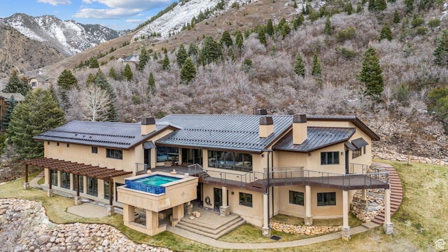 4552 S Zarahemla Dr E, Salt Lake City, UT 84124 - rear view of property featuring metal roof, a chimney, stairway, stucco siding, and a standing seam roof