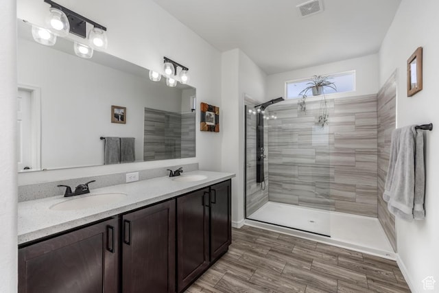 bathroom featuring tiled shower and vanity