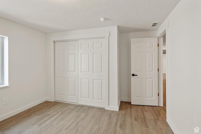 3492 N Delta St, Eagle Mountain, UT 84005 - unfurnished bedroom featuring light hardwood / wood-style floors, a textured ceiling, and a closet