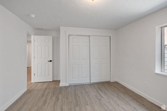 3492 N Delta St, Eagle Mountain, UT 84005 - unfurnished bedroom with light wood-type flooring, a textured ceiling, and a closet