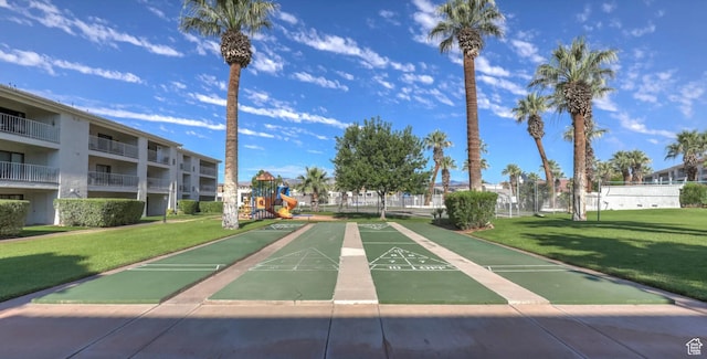 view of property's community with a playground and a yard