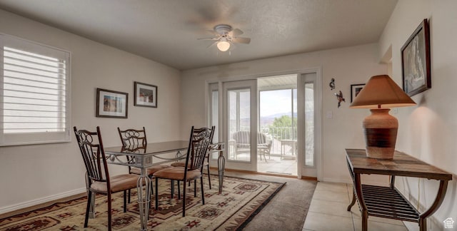 dining room with a textured ceiling, light tile patterned floors, and ceiling fan