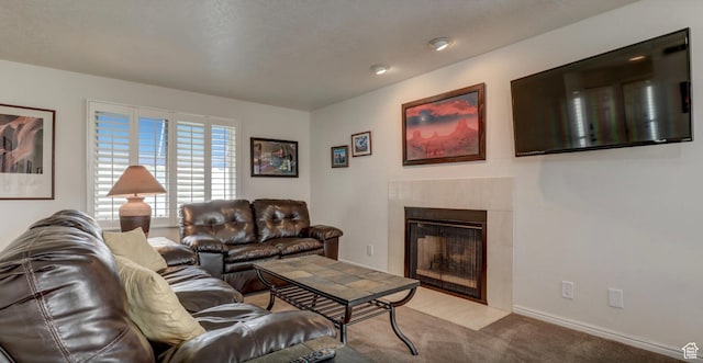 carpeted living room with a tile fireplace