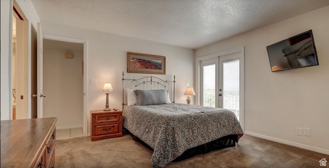 carpeted bedroom featuring access to exterior and a textured ceiling