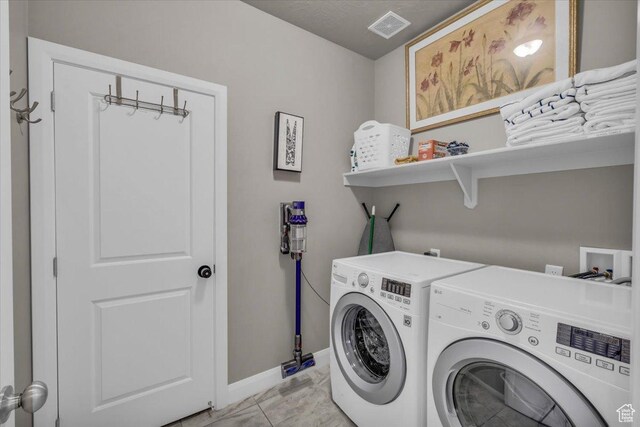 laundry area featuring light tile patterned floors and washer and clothes dryer