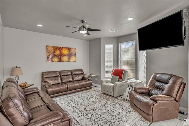 living room featuring ceiling fan, a textured ceiling, and light tile patterned floors