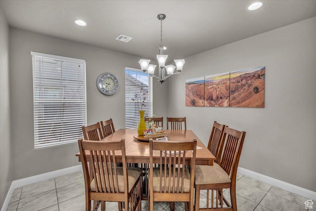 tiled dining area featuring a chandelier