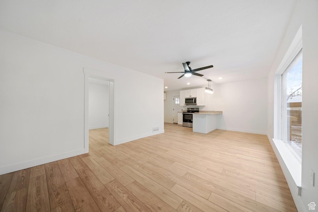 unfurnished living room featuring ceiling fan and light wood-type flooring