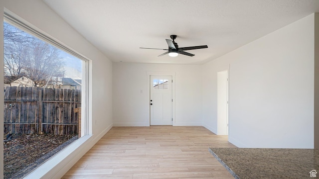 foyer with ceiling fan and light wood-type flooring