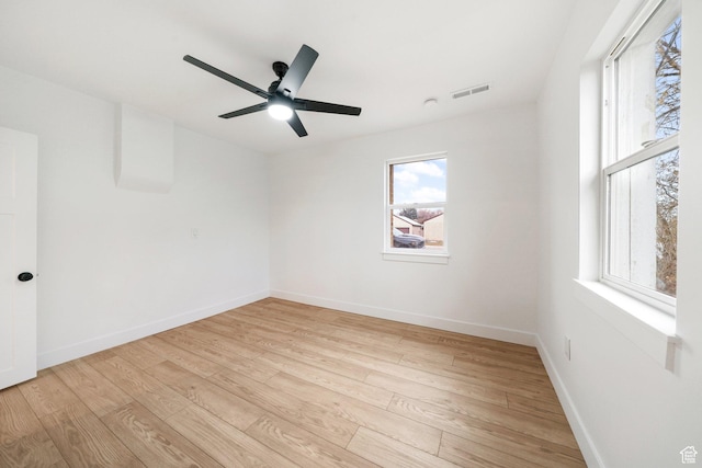 spare room with ceiling fan, a healthy amount of sunlight, and light hardwood / wood-style floors