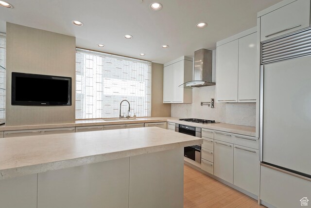 268 S State St E Unit 418, Salt Lake City, UT 84111 - kitchen featuring built in refrigerator, wall chimney range hood, white cabinetry, sink, and wall oven