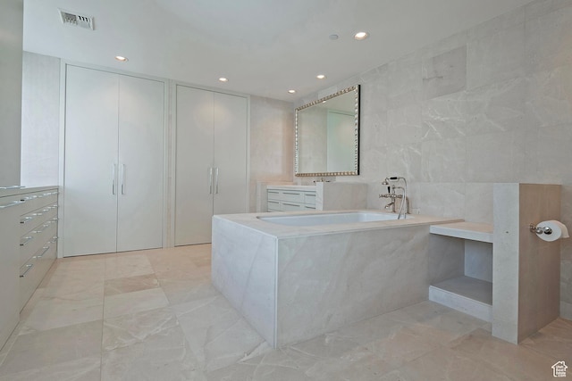 268 S State St E Unit 418, Salt Lake City, UT 84111 - bathroom featuring vanity, tile walls, and a relaxing tiled tub
