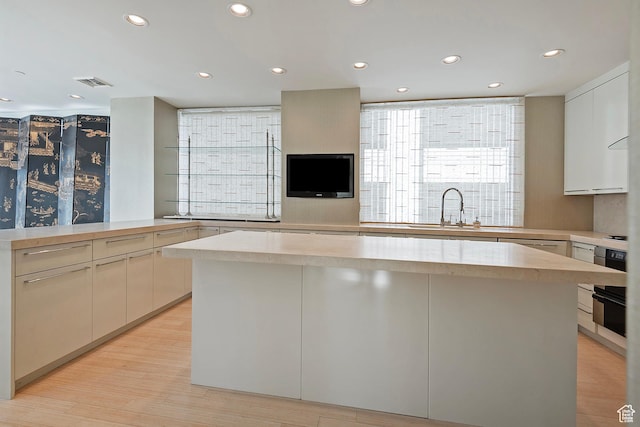 268 S State St E Unit 418, Salt Lake City, UT 84111 - kitchen with kitchen peninsula, sink, light wood-type flooring, oven, and a kitchen island
