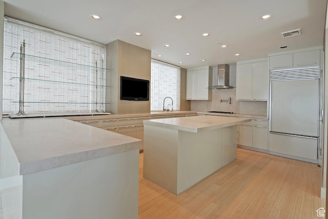 268 S State St E Unit 418, Salt Lake City, UT 84111 - kitchen with wall chimney exhaust hood, white cabinetry, built in refrigerator, gas stovetop, and a kitchen island