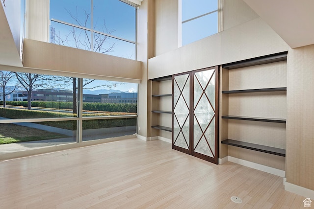 268 S State St E Unit 418, Salt Lake City, UT 84111 - interior space with built in shelves, light hardwood / wood-style floors, and a high ceiling