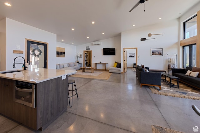 171 E Mt Peale Dr, Moab, UT 84532 - kitchen with dark brown cabinetry, lofted ceiling, an island with sink, sink, and oven