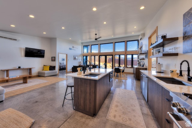 171 E Mt Peale Dr, Moab, UT 84532 - kitchen with sink, a center island with sink, range, and dark brown cabinetry