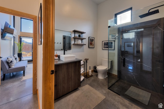 171 E Mt Peale Dr, Moab, UT 84532 - bathroom featuring a shower with shower door, toilet, vanity, and concrete flooring