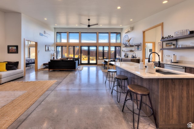 171 E Mt Peale Dr, Moab, UT 84532 - kitchen with concrete floors, a kitchen breakfast bar, a wealth of natural light, and a wall unit AC