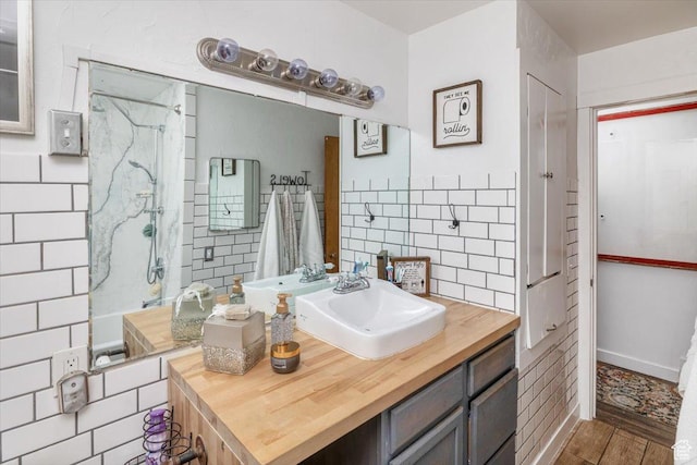 bathroom with vanity and a tile shower