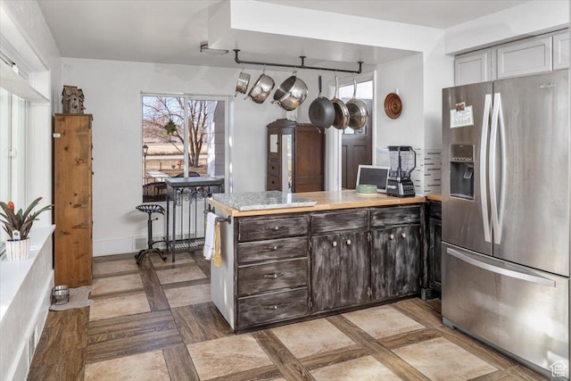 kitchen featuring dark brown cabinets and stainless steel refrigerator with ice dispenser