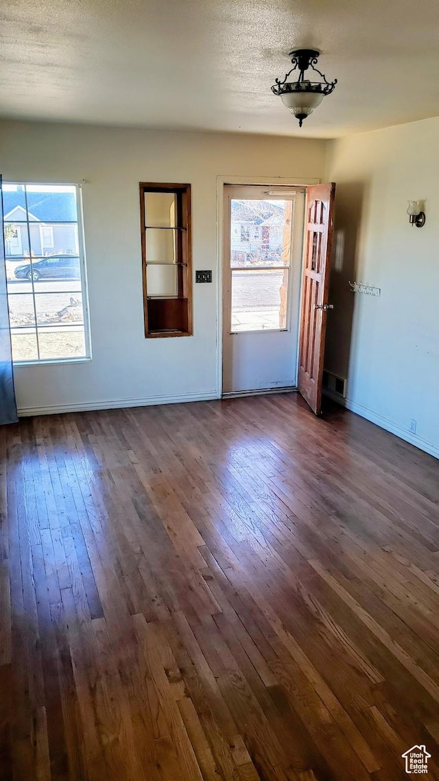 449 E 3rd S, Price, UT 84501 - unfurnished living room with dark wood-type flooring and baseboards