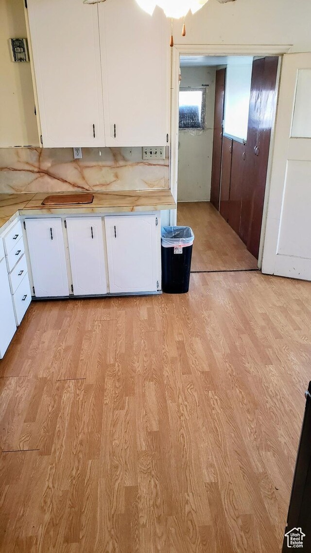 449 E 3rd S, Price, UT 84501 - kitchen featuring light wood-style floors, light countertops, white cabinets, and tasteful backsplash