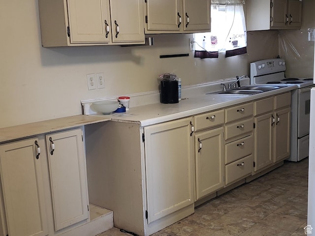 kitchen featuring electric stove, a sink, and light countertops
