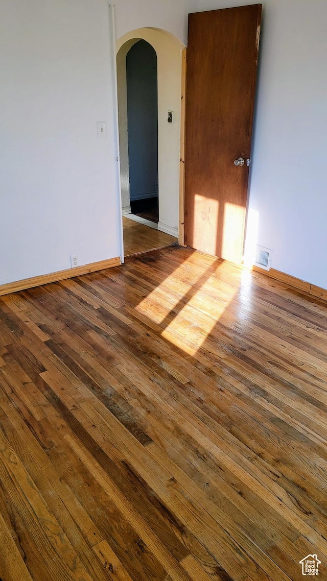 449 E 3rd S, Price, UT 84501 - spare room featuring arched walkways, hardwood / wood-style flooring, and baseboards