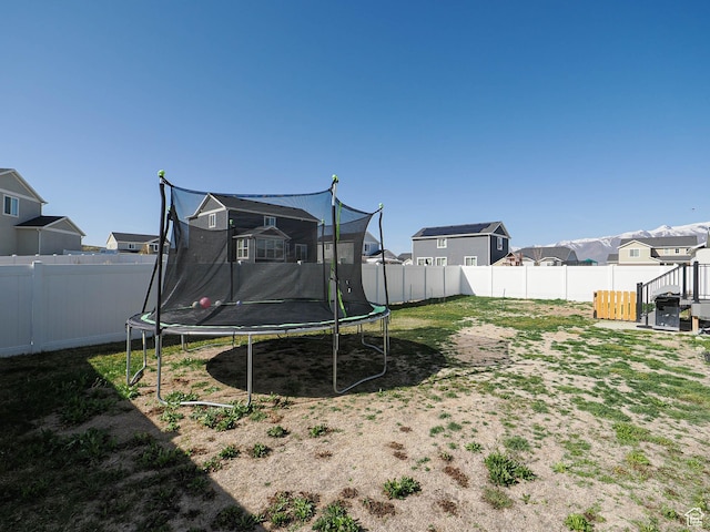 1766 E Johnstown Rd N Unit 710, Eagle Mountain, UT 84005 - view of yard featuring a fenced backyard, a trampoline, and a residential view