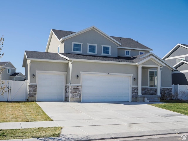 1766 E Johnstown Rd N Unit 710, Eagle Mountain, UT 84005 - view of front facade with concrete driveway, a gate, stone siding, and stucco siding
