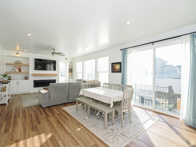 1766 E Johnstown Rd N Unit 710, Eagle Mountain, UT 84005 - dining area with ceiling fan, a fireplace, built in features, recessed lighting, and wood finished floors