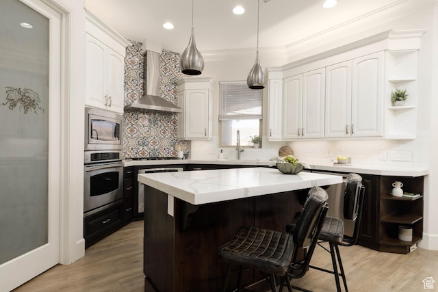 1783 N Firerock Cir, Washington, UT 84780 - kitchen with appliances with stainless steel finishes, wall chimney exhaust hood, sink, white cabinets, and a kitchen island