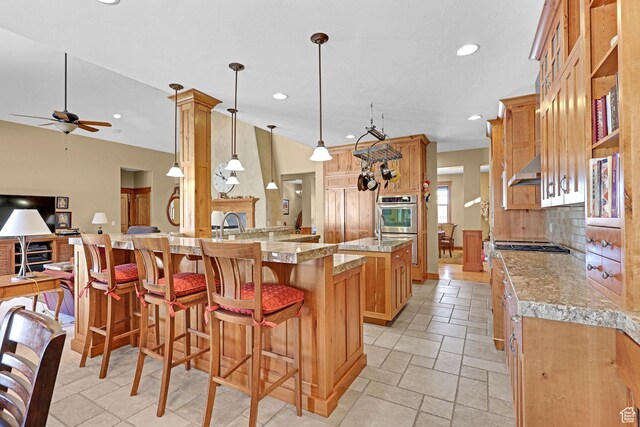 315 S Bear Lake Blvd, Garden City, UT 84028 - kitchen with ceiling fan, double oven, backsplash, a breakfast bar area, and recessed lighting