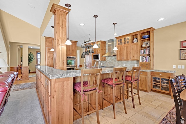 315 S Bear Lake Blvd, Garden City, UT 84028 - kitchen with wall chimney range hood, appliances with stainless steel finishes, backsplash, recessed lighting, and hanging light fixtures