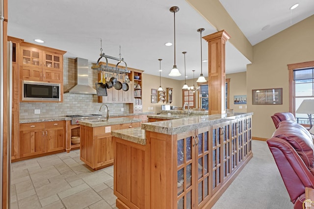315 S Bear Lake Blvd, Garden City, UT 84028 - kitchen with wall chimney range hood, built in microwave, an island with sink, backsplash, and open floor plan
