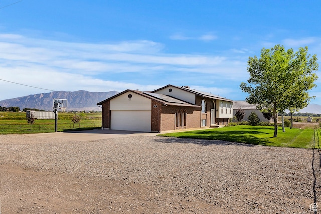 712 S 6150 W, Ogden, UT 84404 - view of front of home featuring a garage, a mountain view, and a front lawn