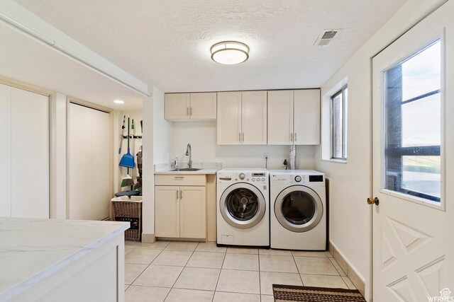 712 S 6150 W, Ogden, UT 84404 - laundry area with a textured ceiling, washer and clothes dryer, cabinets, sink, and light tile patterned floors