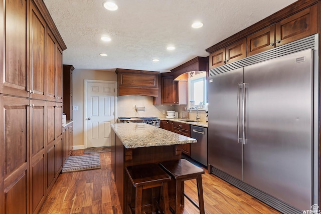 712 S 6150 W, Ogden, UT 84404 - kitchen with custom exhaust hood, appliances with stainless steel finishes, tasteful backsplash, sink, and a kitchen island