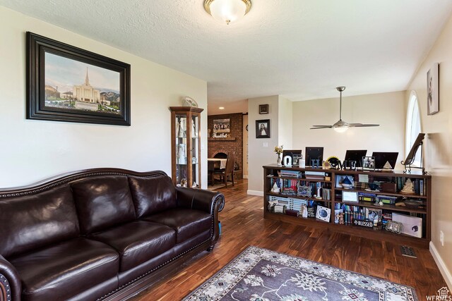 712 S 6150 W, Ogden, UT 84404 - living room featuring a fireplace, a textured ceiling, dark hardwood / wood-style floors, and ceiling fan