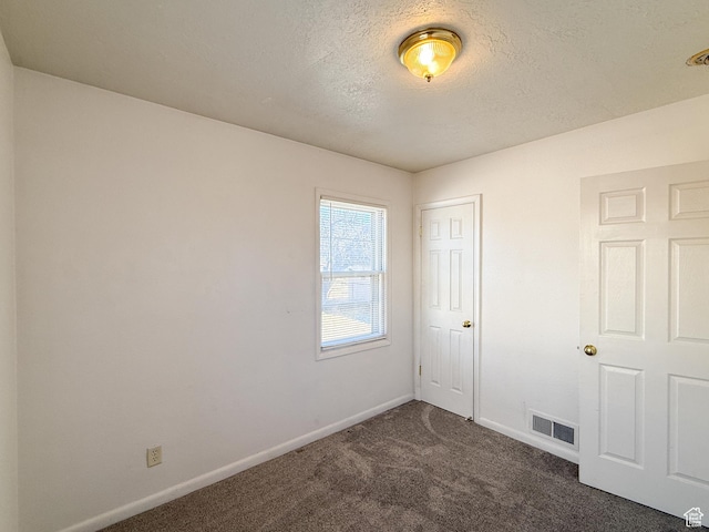 5840 S 2625 W, Roy, UT 84067 - unfurnished bedroom with baseboards, dark carpet, a textured ceiling, and visible vents