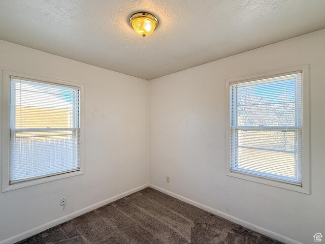 5840 S 2625 W, Roy, UT 84067 - unfurnished room featuring baseboards, a textured ceiling, and dark colored carpet