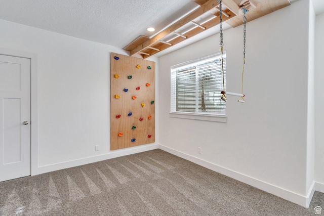 unfurnished room with carpet flooring and a textured ceiling