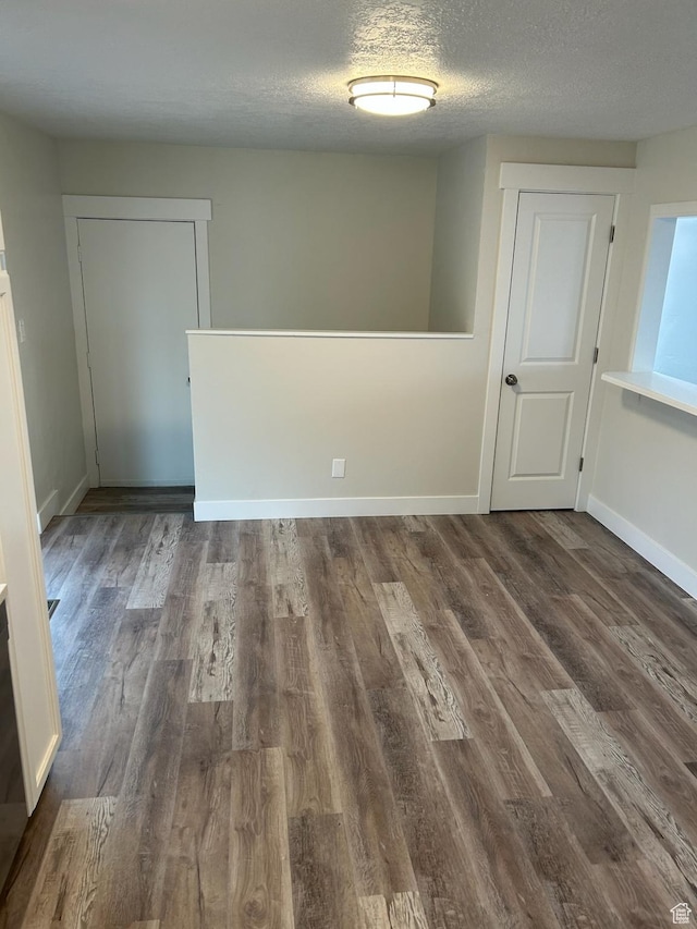 spare room with dark hardwood / wood-style flooring and a textured ceiling