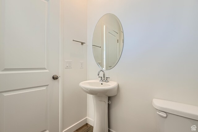 bathroom featuring sink, toilet, and wood-type flooring