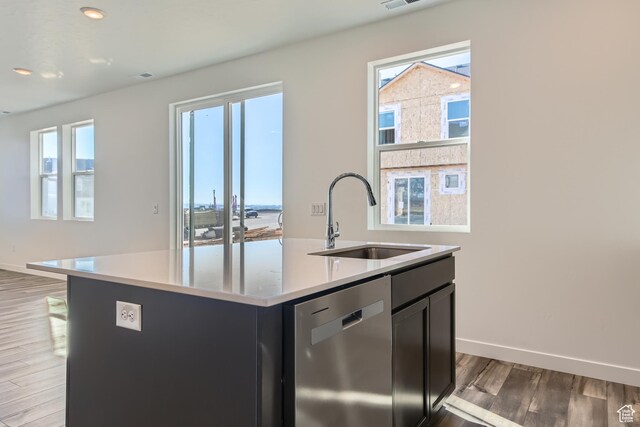 kitchen with sink, dishwasher, a center island with sink, and light hardwood / wood-style floors