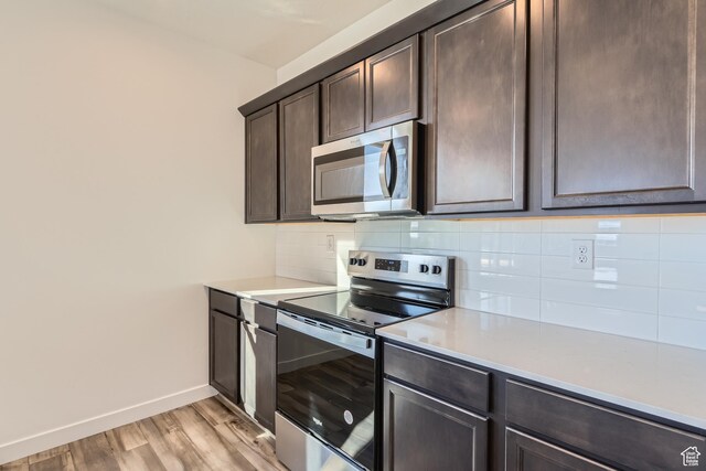 kitchen with dark brown cabinets, light hardwood / wood-style floors, appliances with stainless steel finishes, and decorative backsplash