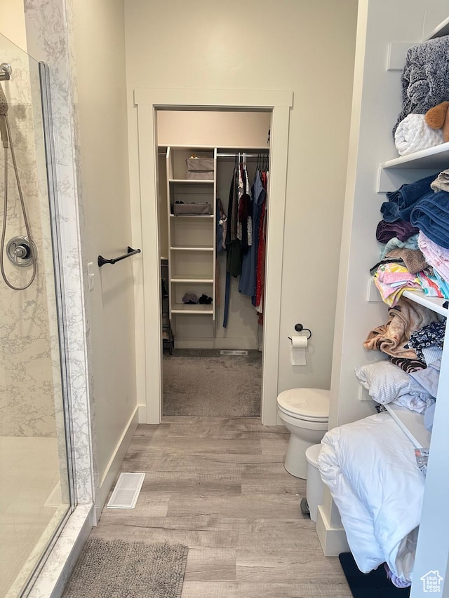 3 W 825 S, Willard, UT 84340 - full bathroom with wood finished floors, a shower stall, toilet, and a walk in closet